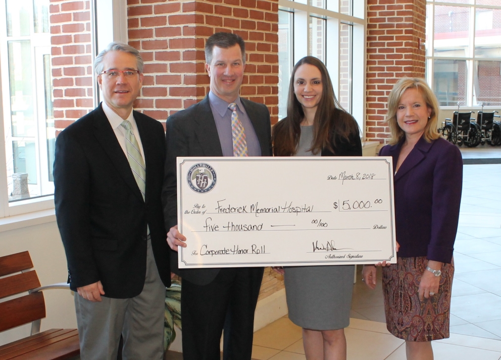 Group of people holding a large sized check